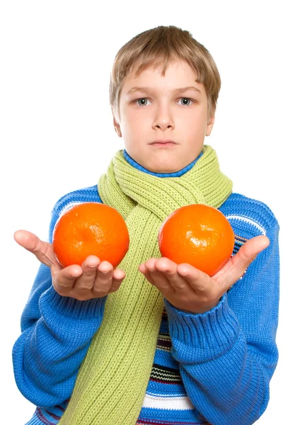 Teen ukazuje pomeranče. přivázal teplý šátek. — Stock fotografie
