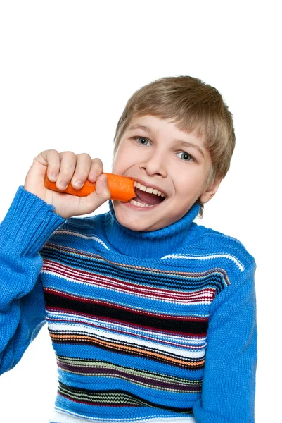 Tonåring äter morötter. Han har starka tänder. — Stockfoto