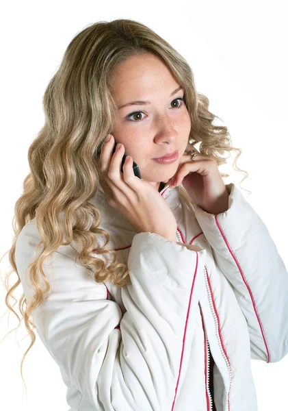 Дівчина в білій куртці з мобільним телефоном — стокове фото