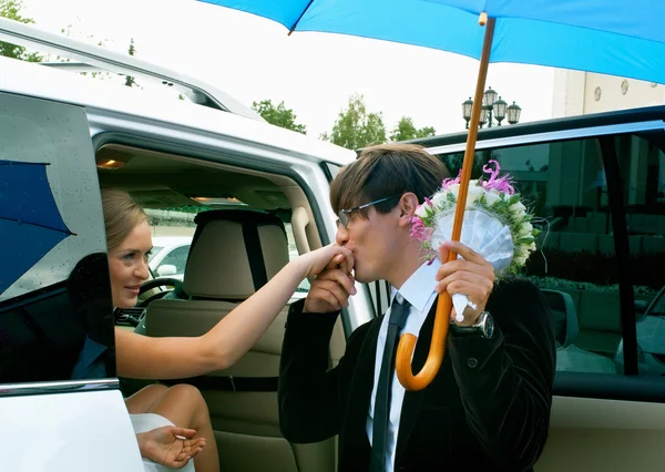 Жених и невеста против белого автомобиля — стоковое фото