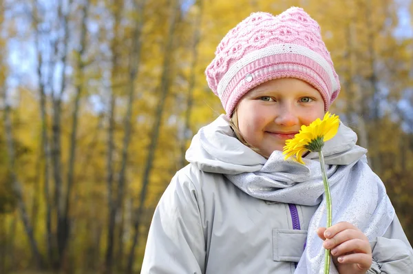 Liten flicka med en gul blomma — Stockfoto