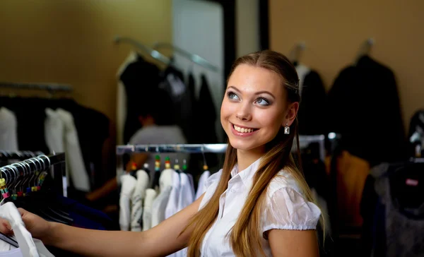 Jonge vrouw in een winkel kleding kopen — Stockfoto