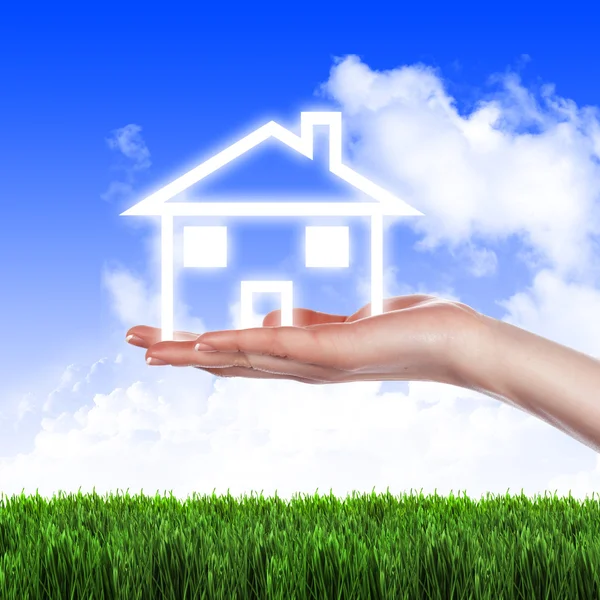 Hus i händerna mot den blå himlen — Stockfoto