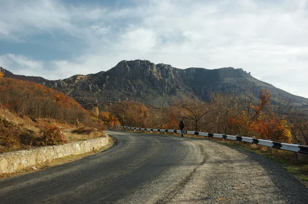 Lonely traveler on the mountain road at Crimea natural reserve, — Stock Photo, Image