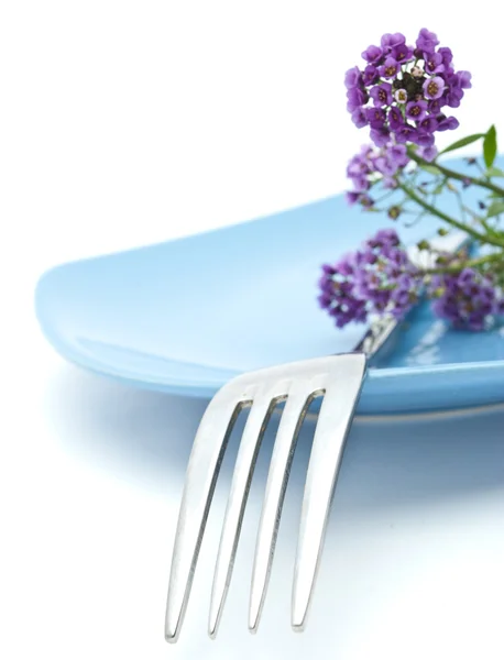 Цветы, тарелка и вилка изолированы на белом фоне — стоковое фото