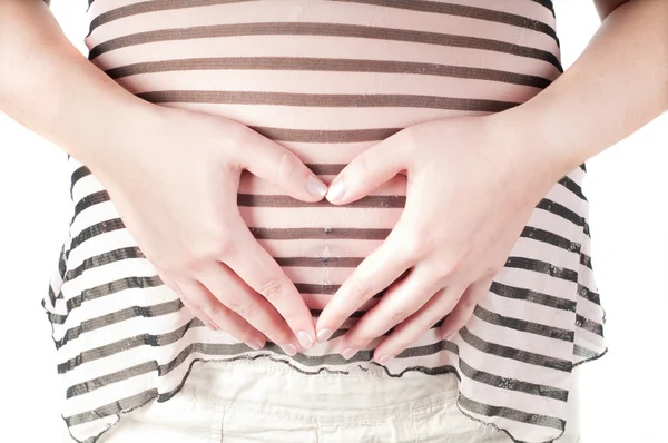 Těhotná žena s rukama ve formě srdce znamení — Stock fotografie