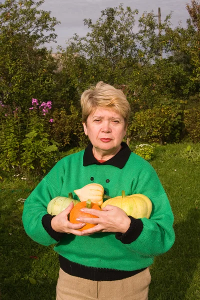 Senior vrouw met pompoenen — Stockfoto