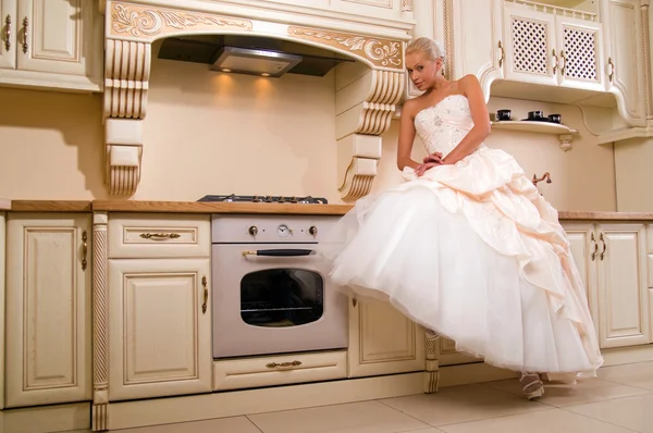 Attractive bride sitting in the kitchen — Stock Photo, Image