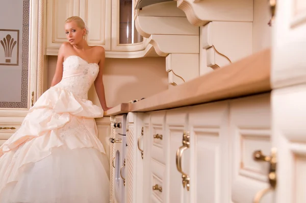 Schöne Braut steht in der Küche — Stockfoto