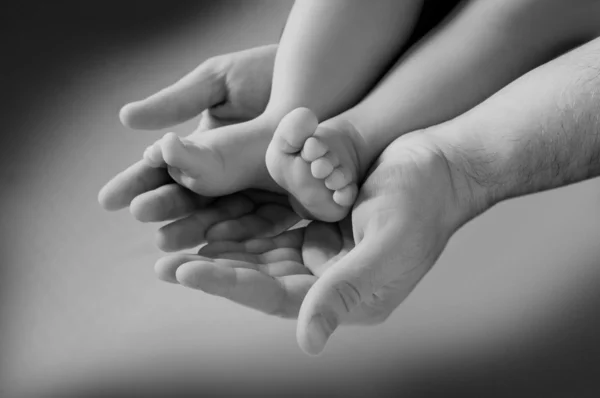 Man's hand and children's foot — Stock Photo, Image