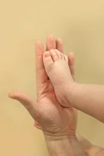 Ręka mężczyzny i stopy dziecka — Zdjęcie stockowe