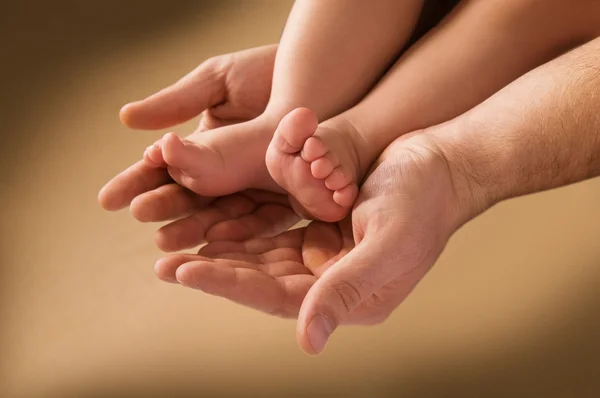 A mão do homem e o pé das crianças — Fotografia de Stock