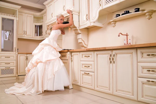 Schöne Braut steht in der Küche — Stockfoto