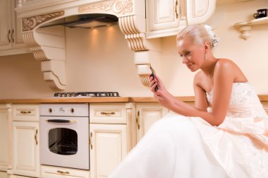 Beautiful bride in the kitchen and laughs clipart
