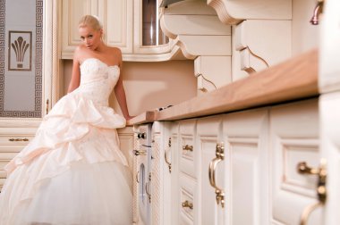 Bride stands in the kitchen and laughs clipart