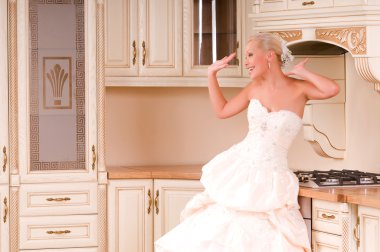 Bride stands in the kitchen and laughs clipart