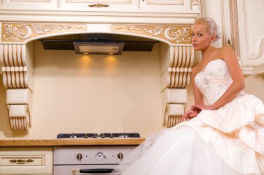 Beautiful bride stands in the kitchen clipart