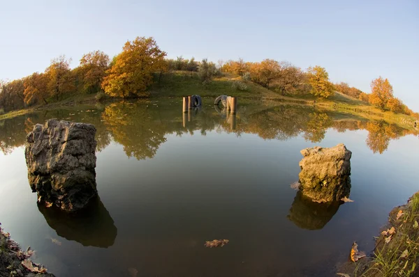 Flödet av vatten bland stenar och löv — Stockfoto