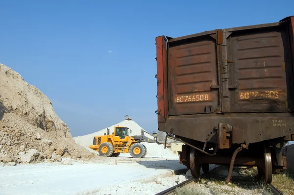挖掘机将碎石加载到的火车车 — 图库照片