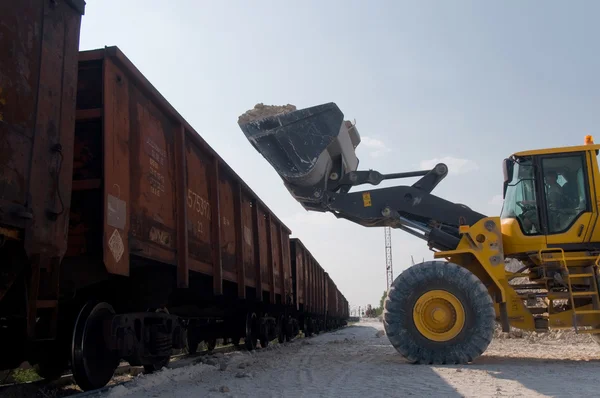 挖掘机将碎石加载到的火车车 — 图库照片