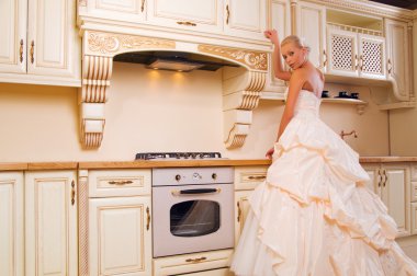 Beautiful bride stands in the kitchen clipart