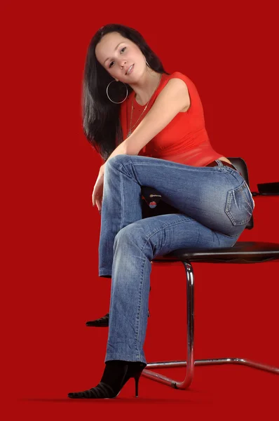 Ung kvinna sitter på en stol — Stockfoto