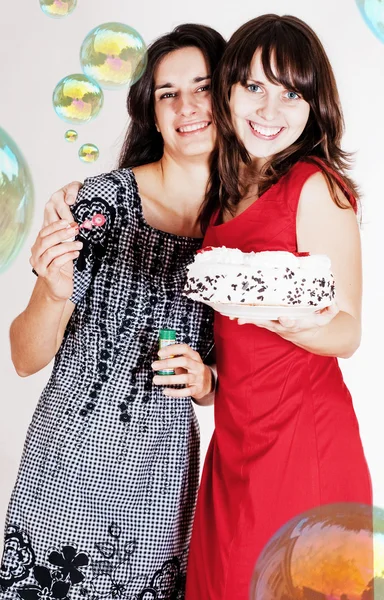 Meninas de beleza com bolas de sabão e bolo doce — Fotografia de Stock