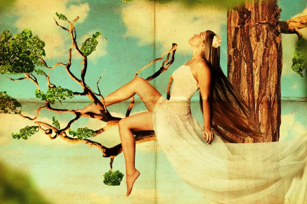 Schönheit junge Frau auf Baum in den Himmel — Stockfoto