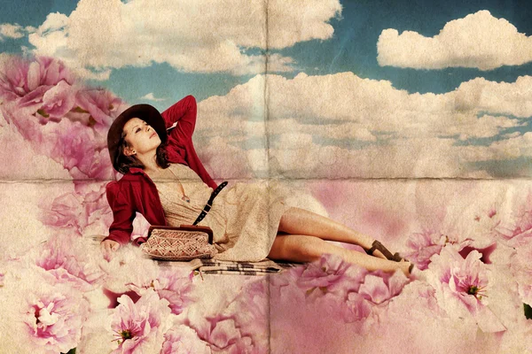 Schönheit junge Frau liegen in rosa Blumen — Stockfoto