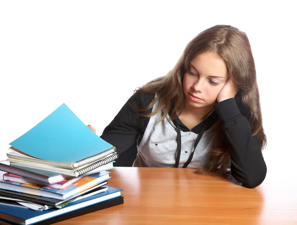The girl-teenager looks at pile of books — Stock Photo, Image