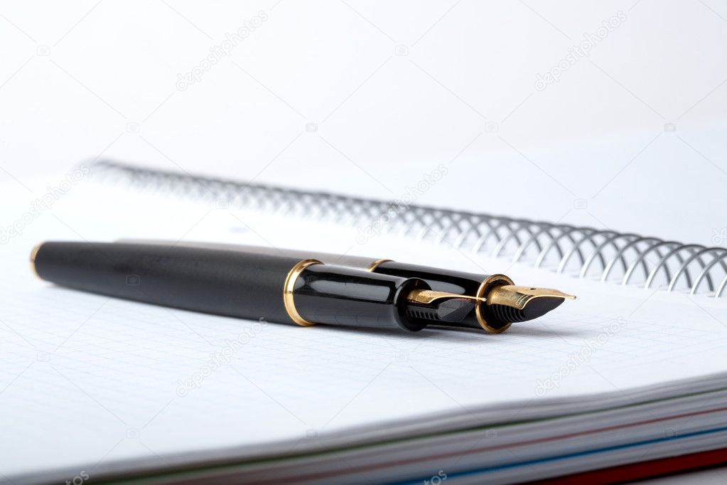 Fountain pens lays on a writing-book