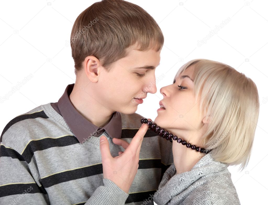 Girl kisses the young man on a white background