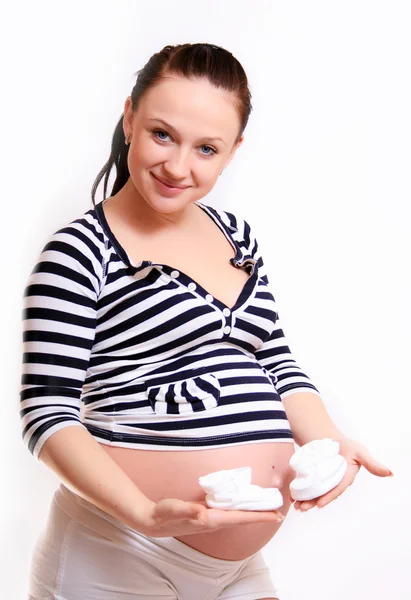 怀孕的妻子在她怀孕的肚子上举行小袜子 — 图库照片