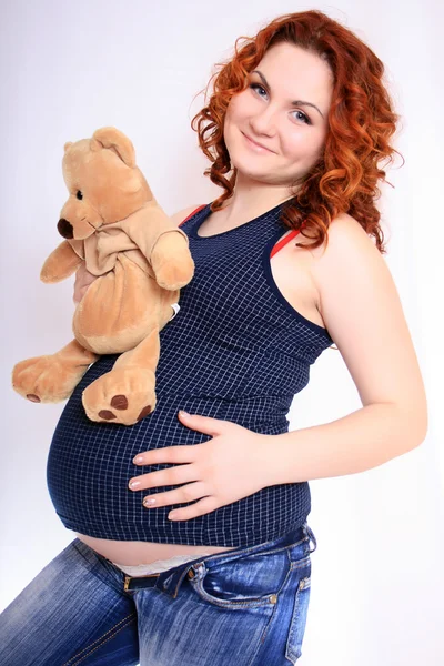 与泰迪熊的沉重怀孕的女人肚子 — 图库照片