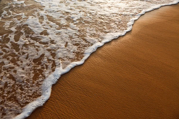 Welle wogt auf Sand am Strand. — Stockfoto