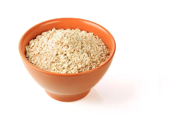 Descrizione: Cereali di avena secca in ciotola di argilla marrone — Foto Stock