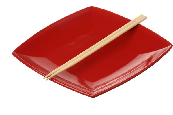 Палочки для еды на красной тарелке — стоковое фото