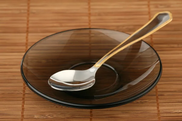Teaspoon on a saucer — Stock Photo, Image