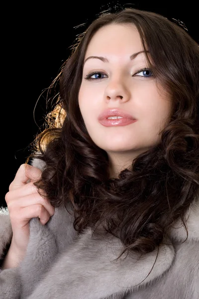 Attractive young woman in a fur coat — Stockfoto