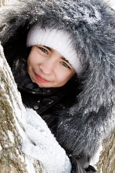 Menina bonita perto de uma árvore na neve . — Fotografia de Stock