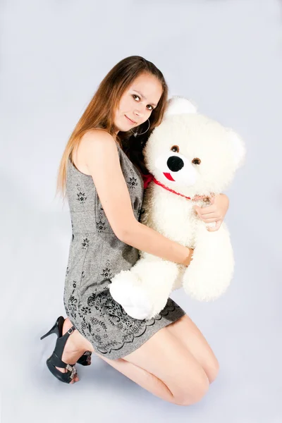 Portret van het mooie meisje met een stuk speelgoed een teddy beer. — Stockfoto