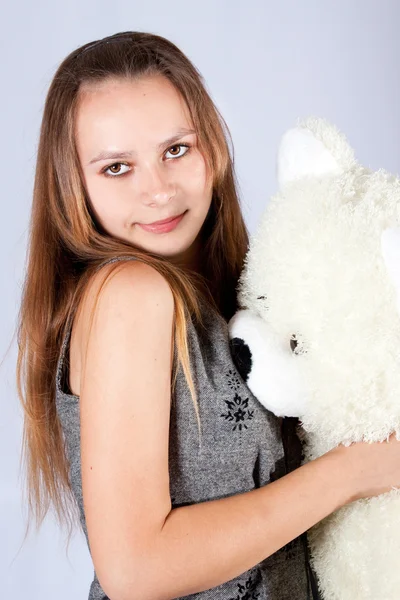 Portret van het mooie meisje met een stuk speelgoed een teddy beer. — Stockfoto
