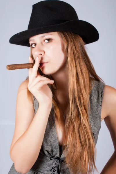 Portrait of the beautiful and stylish girl in a hat with a cigar — Stock Photo, Image