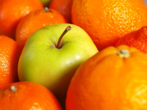 Apple among oranges — Stock Photo, Image