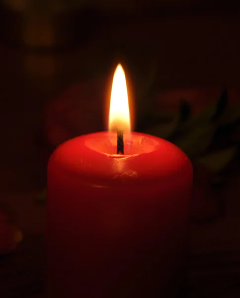 Uma vela conflagrante está na escuridão — Fotografia de Stock