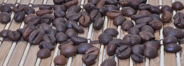 Granos de café en soporte de bambú —  Fotos de Stock