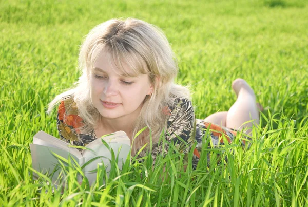 Молода красива дівчина читає книгу на відкритому повітрі — стокове фото