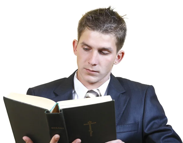 Молодой человек в костюме изучает Библию — стоковое фото