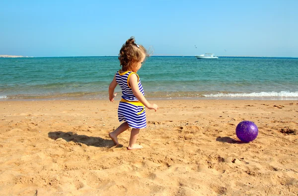 Девушка играет с мячом на пляже — стоковое фото
