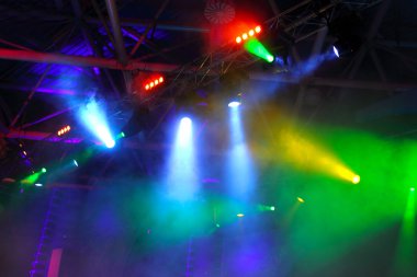 lighting equipment at concert - colored spotlights on ceiling in smoke clipart